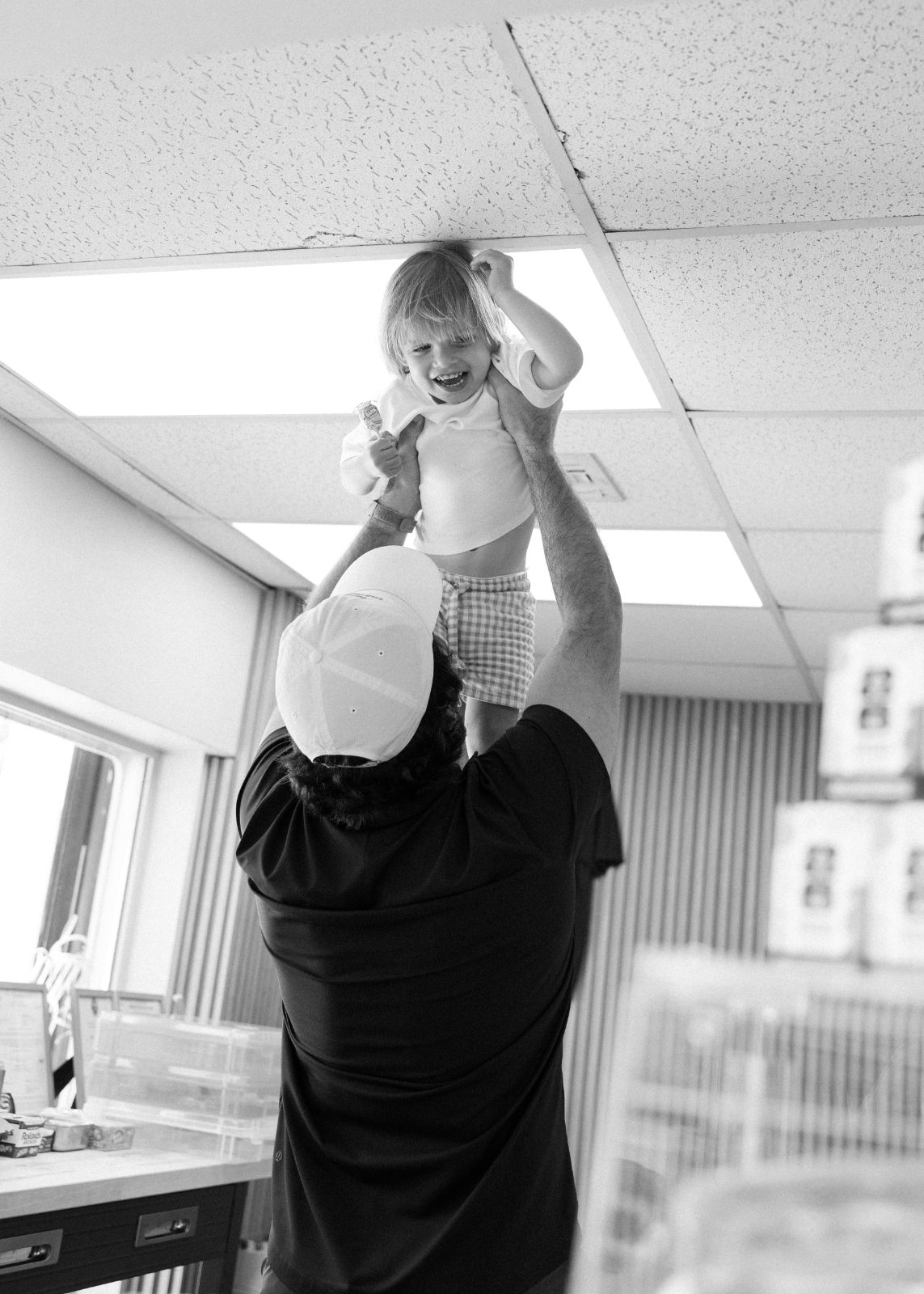A father lifting his kid inside Bodega Ortega